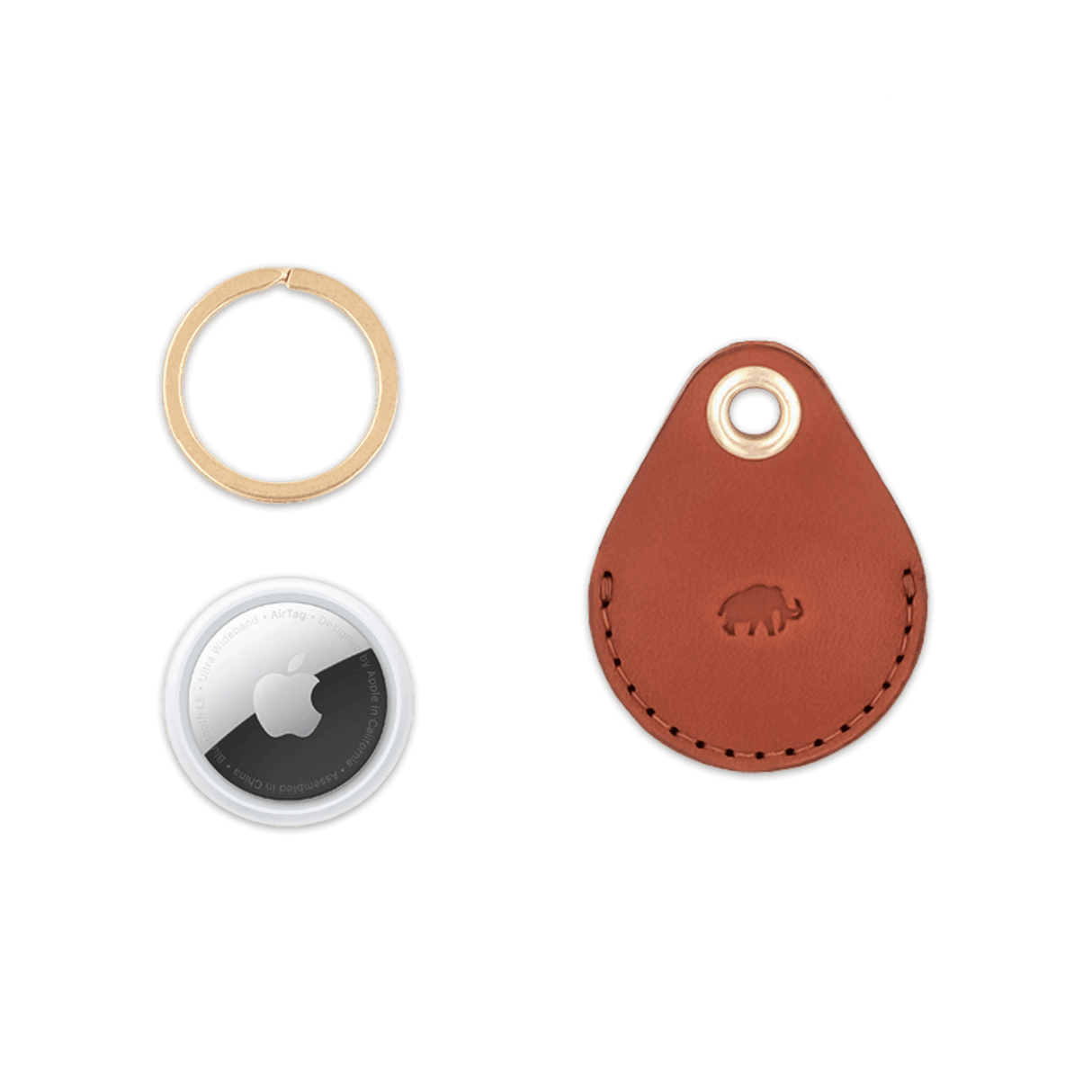 Brown leather AirTag case with debossed Woolly Made logo, brass hardware, and AirTag for scale.