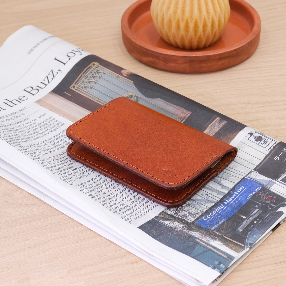 Woolly Made Flip Wallet in Brown. On top of a recent New York Times Newspaper.