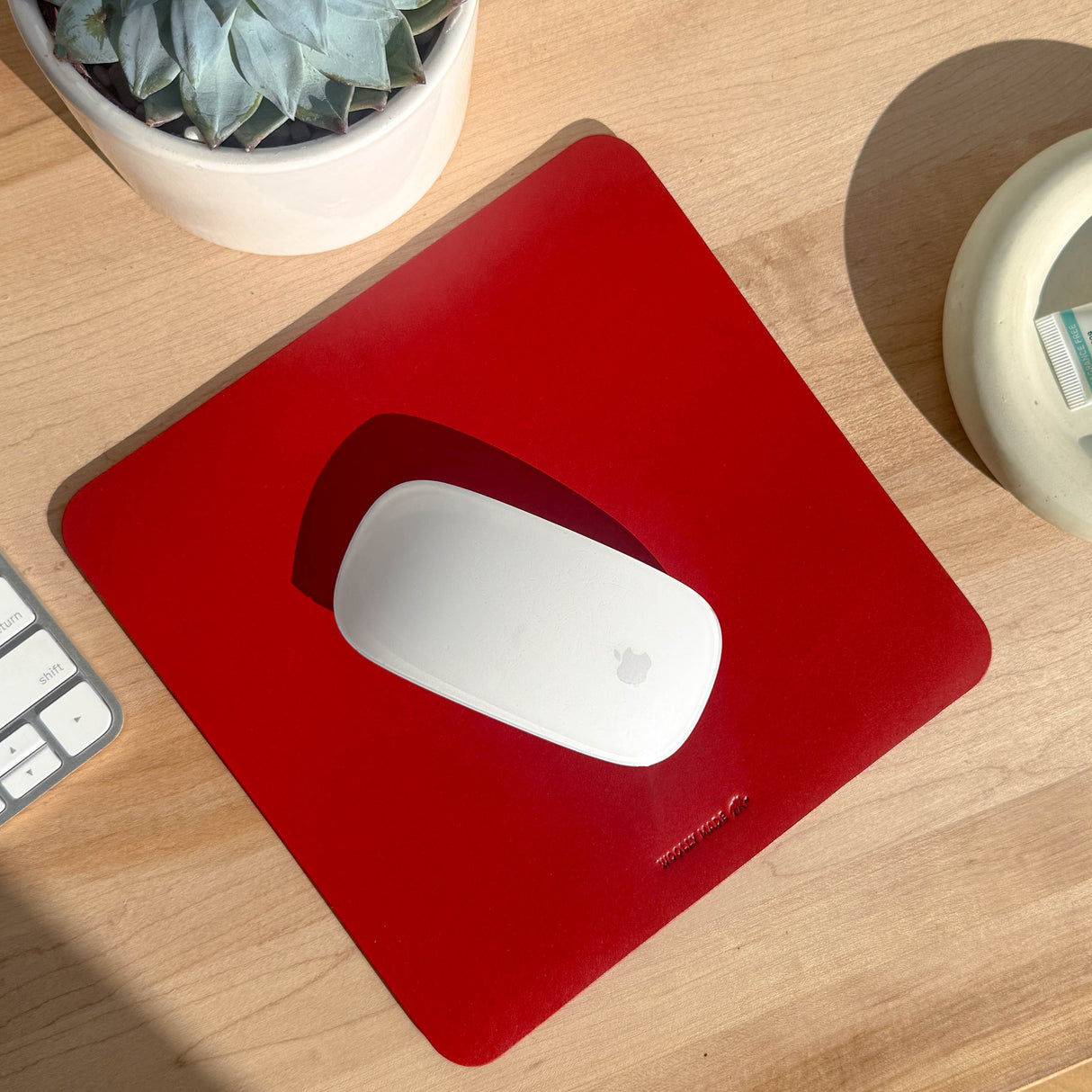 Red mouse pad with debossed corporate logo, ideal for promotional gifting.