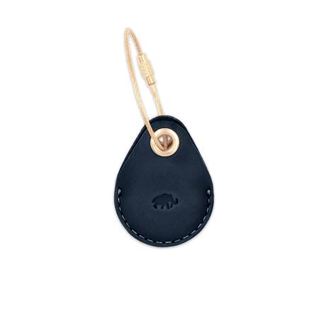 Navy leather AirTag case with debossed Woolly Made logo and brass luggage loop.