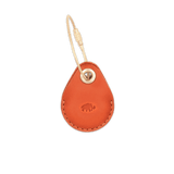 Orange leather AirTag case with debossed Woolly Made logo and brass luggage loop.