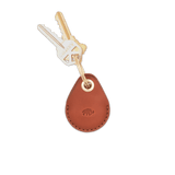 Brown leather AirTag case with debossed Woolly Made logo, brass hardware, and keys.