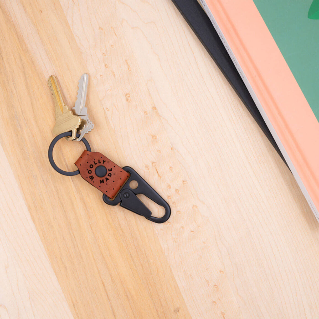 Brown leather Clip Keychain, etched Woolly Made logo, decorative perforation, black hardware, books.