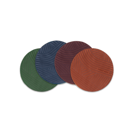 Brown, burgundy, navy, green leather round Texture coasters spread, hand-pressed Woolly Made logo.