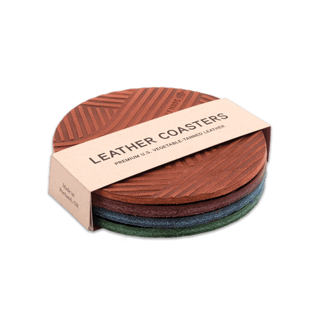 Brown, burgundy, navy, green leather round Texture coasters stacked, hand-pressed Woolly Made logo.