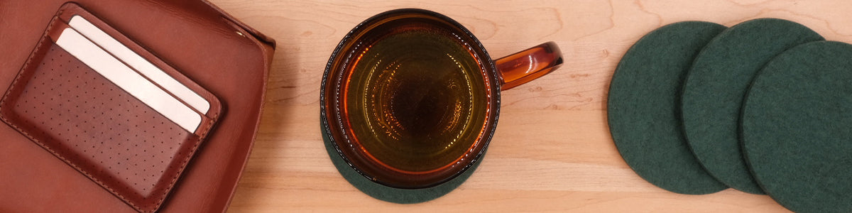 Green Woolsters set with glass of water and tabletop accessories.