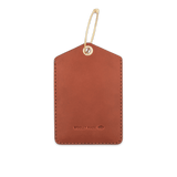 Brown leather Luggage Tag back view with hand-pressed Woolly Made logo and brass hardware.