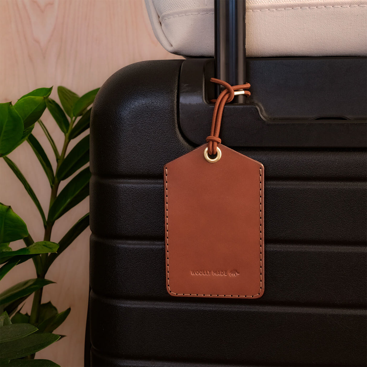 Executive Luggage Tag in brown leather on a black suitcase.