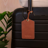 Executive Luggage Tag in brown leather on a black suitcase.