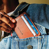 Brown Half Wallet coming out of a jacket pocket.