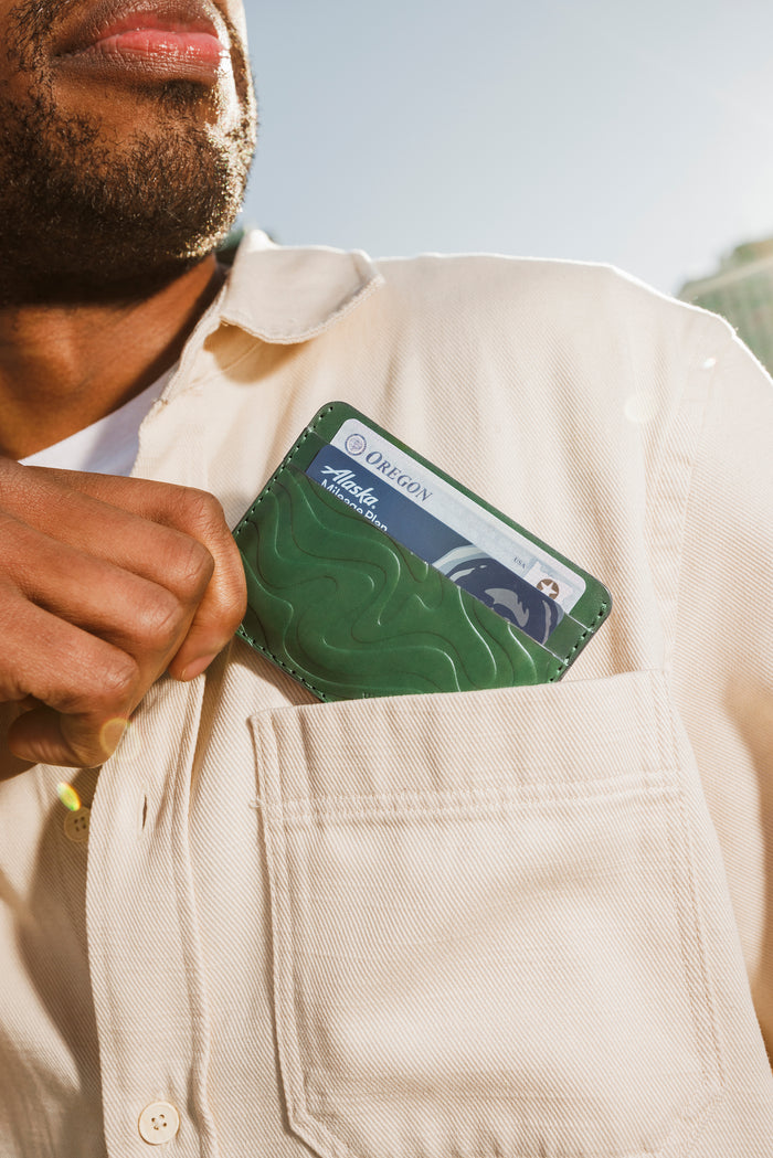 Green Texture Half Wallet coming out of a pocket.