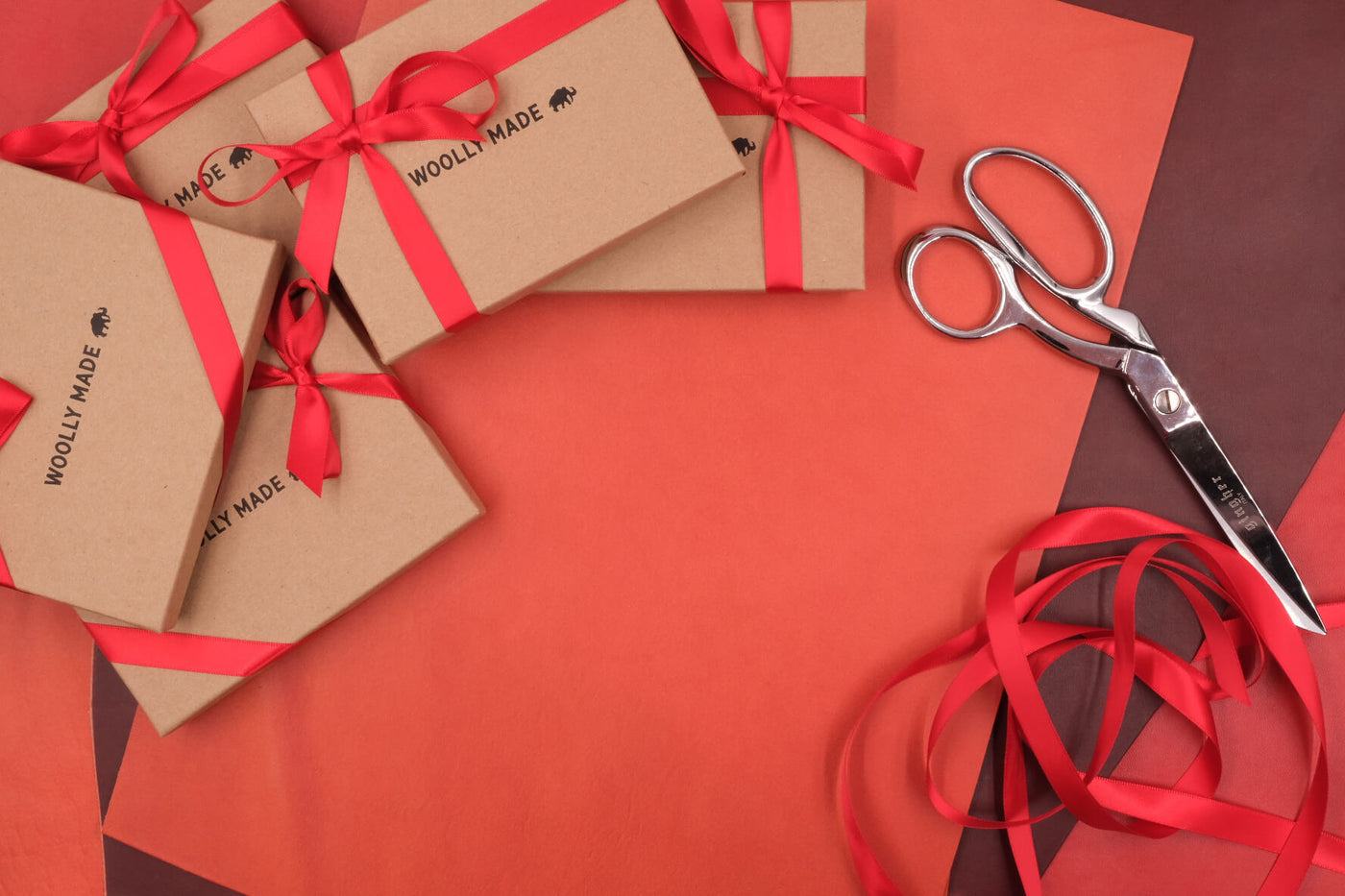 Boxes with red bows, scissors, and red ribbon.