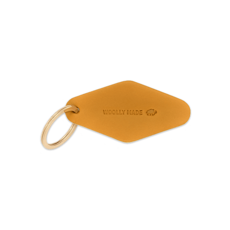Gold leather diamond-shaped Hotel Keychain with hand-pressed Woolly Made logo and brass hardware.