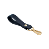 Navy leather Loop Keychain 3/4 angle view with brass hardware and hand-pressed Woolly Made logo.