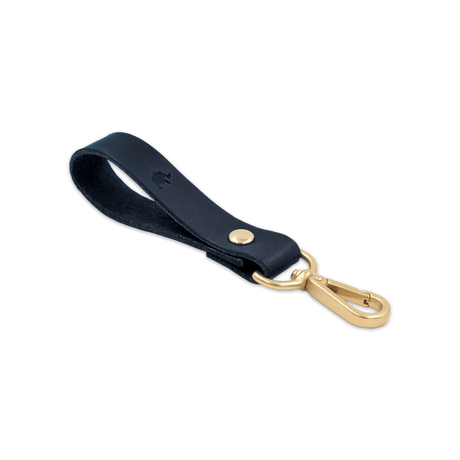 Navy leather Loop Keychain 3/4 angle view with brass hardware and hand-pressed Woolly Made logo.