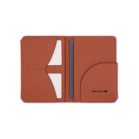 Brown leather Passport Wallet open view with etched Woolly Made logo, white cards, and passport.