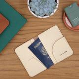 Woolly Made Passport Wallet in Tusk. On a wooden table near a succulent and a stack of books.