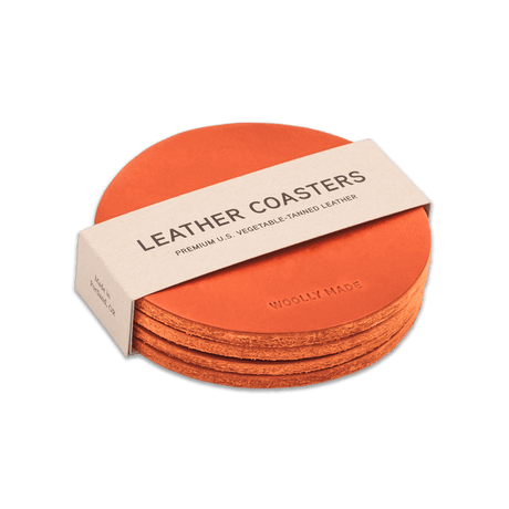 Orange leather round coaster set with hand-pressed Woolly Made logo stacked.