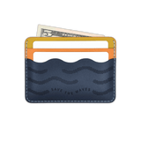 Yellow, orange, navy leather, wave pocket, etched Save the Waves text, white cards, $5 bill.