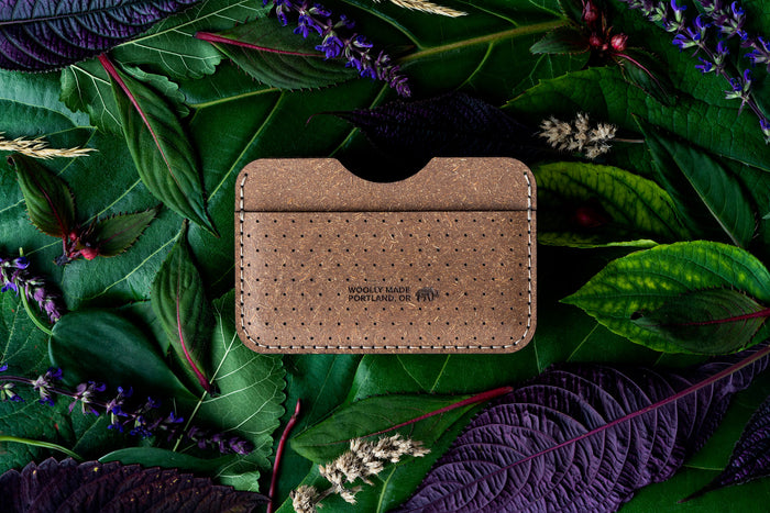 Top down view of the Plant Slim Wallet with decorative perforation and the Woolly Made logo on top of leaves and flowers.