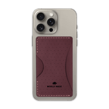 Burgundy leather Stick-On Wallet with decorative perforation and etched Woolly Made logo on iPhone.