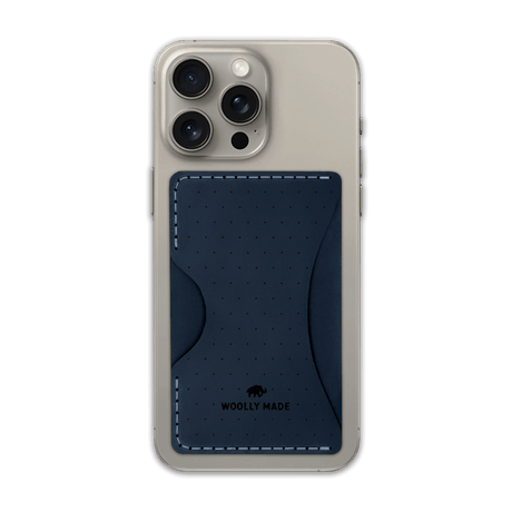 Navy leather Stick-On Wallet with decorative perforation and etched Woolly Made logo on iPhone.