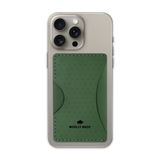 Green leather Stick-On Wallet with decorative perforation and etched Woolly Made logo on iPhone.