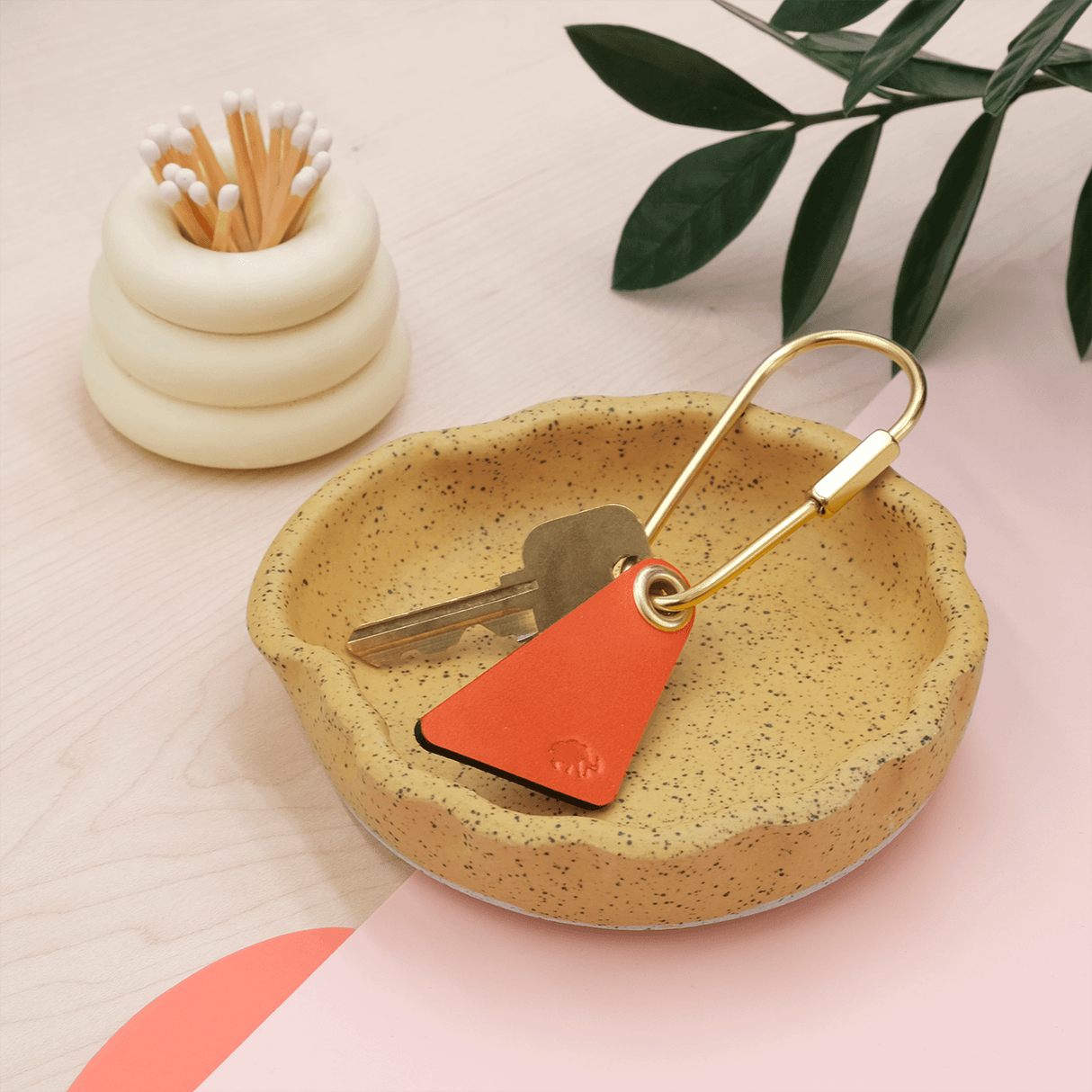 Teardrop Keychain in orange leather in a lifestyle scene.