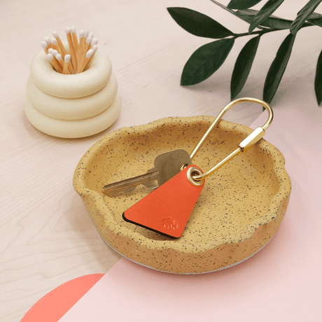 Teardrop Keychain in orange leather in a lifestyle scene.