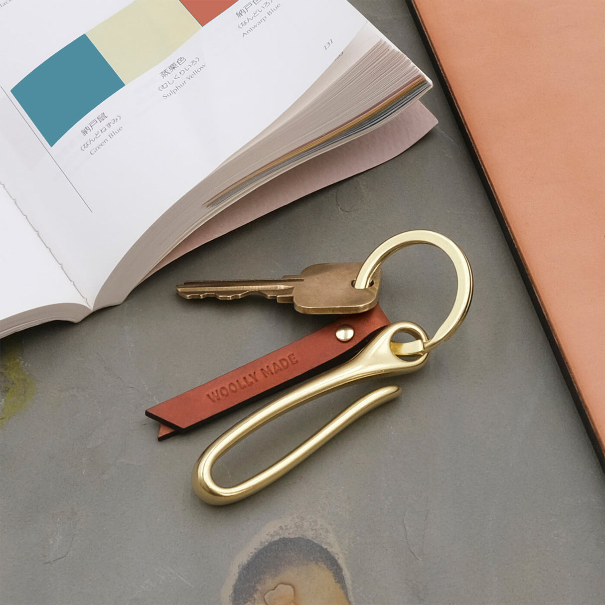 Woolly Made Fish Hook Keychain in brown leather in a lifestyle scene.