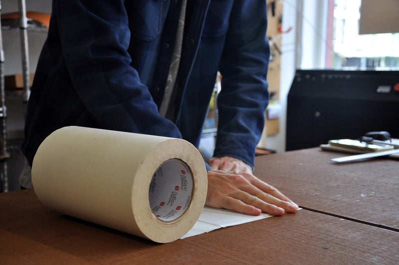 Hands preparing leather for laser cutting.